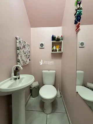 Foto de um banheiro com pia e vaso sanitário em uma residência.