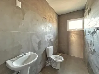Banheiro com pia e vaso sanitário em um ambiente com revestimento de cerâmica.