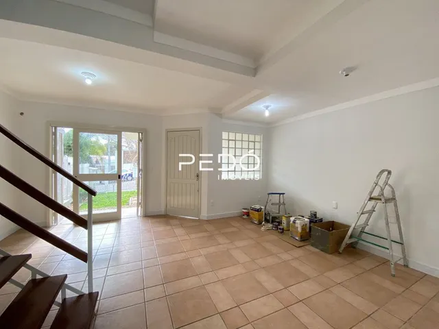Interior de uma sala com piso de cerâmica e escada visível.