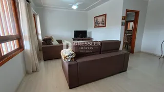 Sala de estar com sofá marrom e janela.