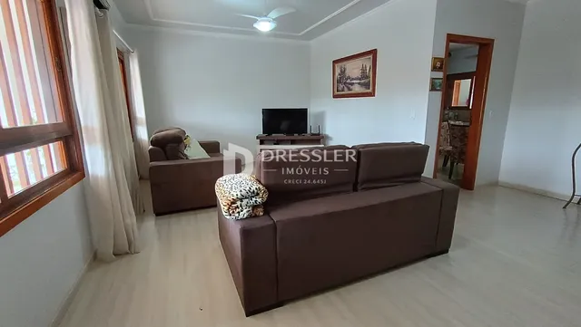 Sala de estar com sofá marrom e janela.