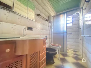 Banheiro com revestimento cerâmico nas paredes e porta de vidro.