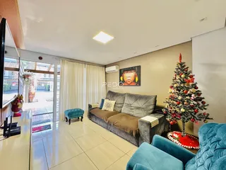 Sala de estar com sofá e árvore de Natal em um imóvel no Brasil.