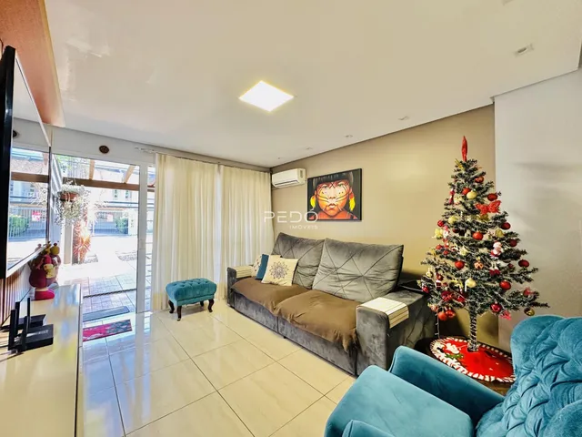 Sala de estar com sofá e árvore de Natal em um imóvel no Brasil.