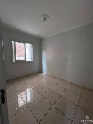 Vista interna de um ambiente com piso de cerâmica e paredes brancas.
