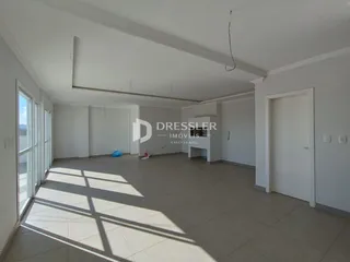 Imagem de um ambiente interno vazio com piso de cerâmica e grandes janelas.