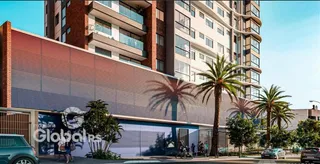 Fachada de um edifício residencial em Lajeado, Brasil, com vegetação tropical na frente.