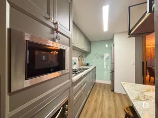 Interior de uma sala de estar com cozinha em um apartamento.