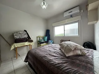 Quarto com cama e janela com persianas.