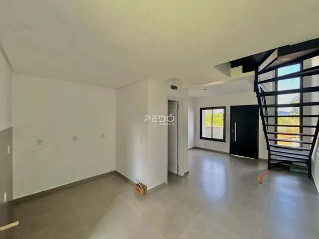 Interior de uma área com piso de cerâmica e paredes brancas.