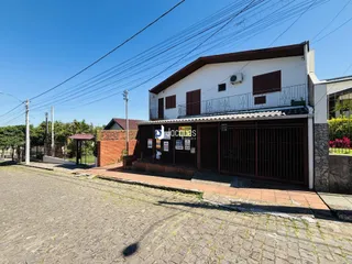 Fachada de uma casa residencial em Lajeado, Brasil, com portão de ferro.
