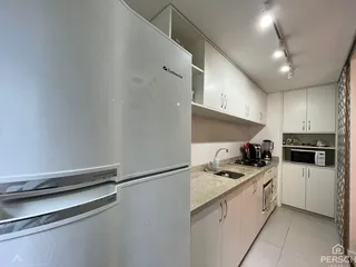 Foto de uma cozinha moderna com armários brancos e bancada.