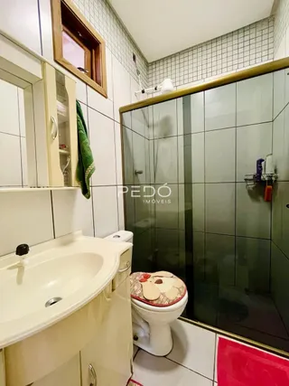 Foto de um banheiro com revestimento de azulejos brancos e box de vidro.