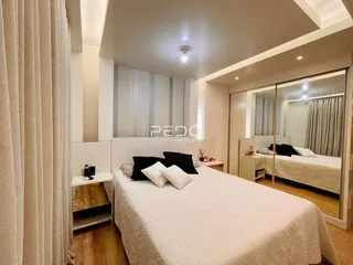 Quarto com cama e paredes brancas em um imóvel.