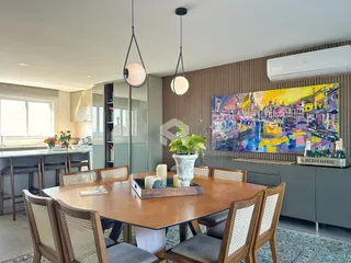 Sala de jantar com mesa de madeira e decoração moderna em uma residência.