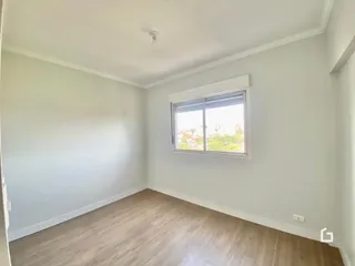 Ambiente interno de uma sala com piso de madeira clara.