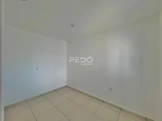 Interior de um cômodo com piso de cerâmica clara e paredes brancas.