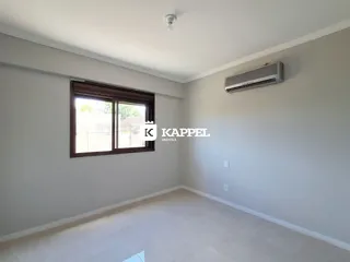 Sala de estar com parede clara, janela e aparelho de ar condicionado instalado.