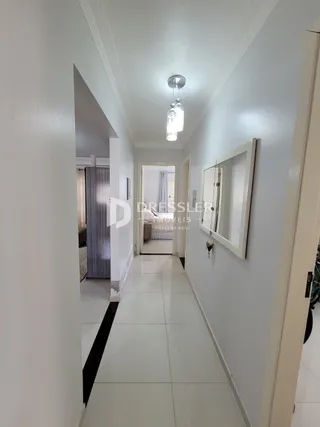 A foto mostra um corredor interno de uma residência.