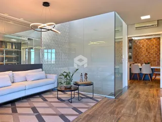 Sala de estar moderna com piso de madeira e divisórias de vidro.