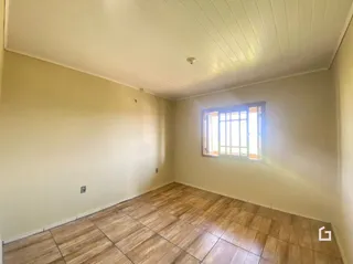 Foto de um cômodo interno com piso de madeira e janela.