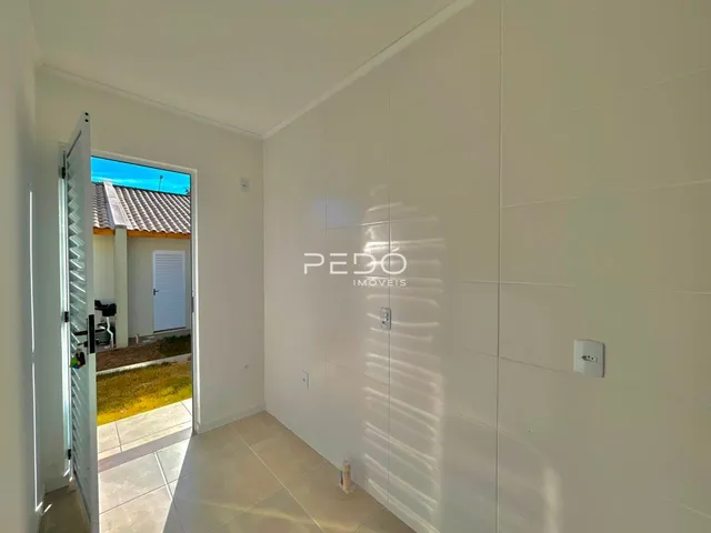 Hall de entrada com piso de cerâmica e porta branca.