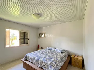 Quarto com cama e janela.