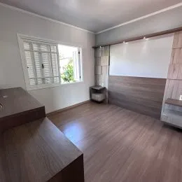 Ambiente interno com piso de madeira e janela na sala.
