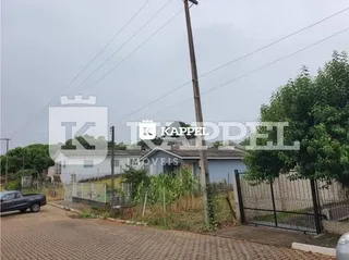 Vista externa de uma propriedade com cerca e poste de utilidade sob um céu nublado.