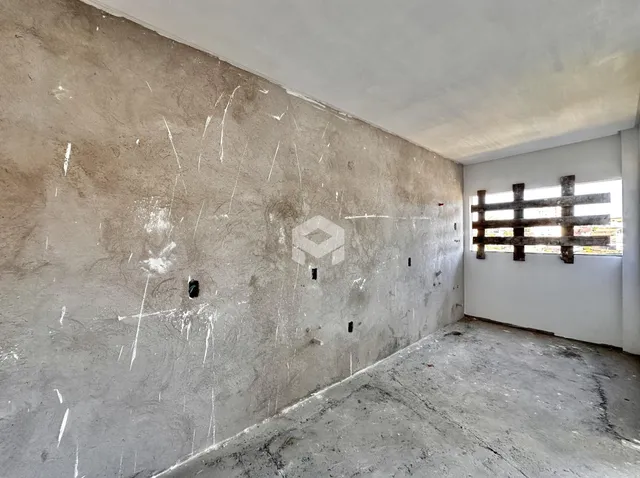 Parede interna com acabamento de concreto aparente em uma residência.