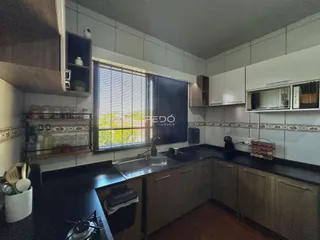 Foto de uma cozinha com armários e janela em um imóvel no Brasil.