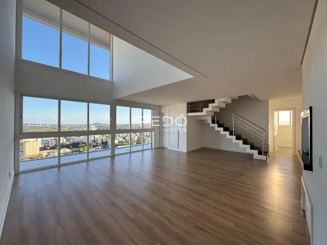 Uma sala de estar ampla com grandes janelas que oferecem uma vista panorâmica da cidade.