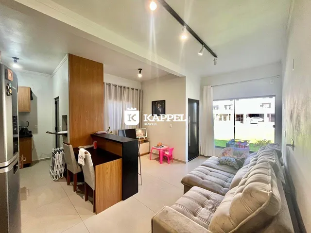 Sala de estar com sofá e vista para o exterior.