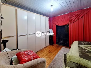 Quarto com armários brancos e piso de madeira.