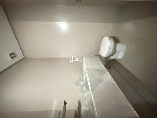Uma foto interna de um cômodo com um vaso sanitário branco.