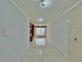 Corredor interno de uma residência com piso de cerâmica clara.