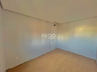 Hall com piso de madeira clara e paredes brancas.