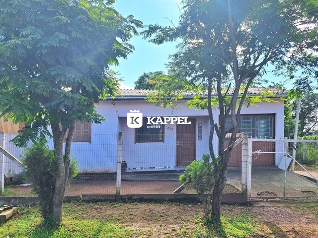 Foto da fachada de uma casa em Lajeado, Brasil, com vegetação densa em primeiro plano.