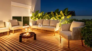 Área externa de lazer com mobiliário e lareira em um deck de madeira.