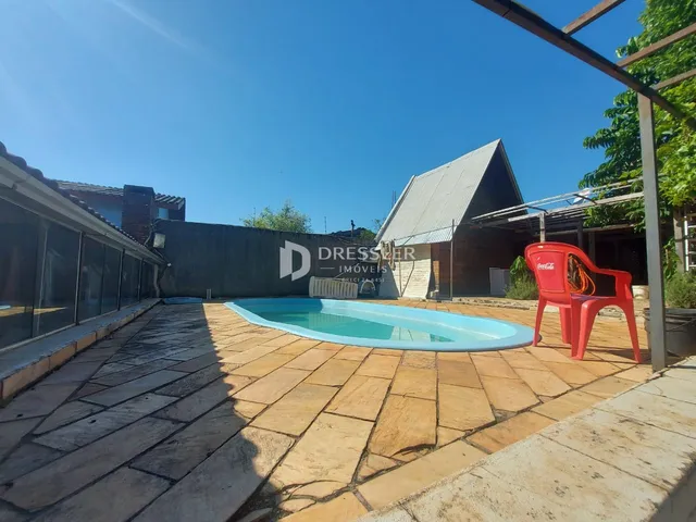 Foto da área externa com piscina e pátio de um imóvel.