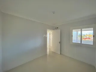 Hall de entrada com paredes brancas e piso claro.