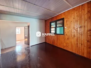 Esta é uma foto de uma sala ampla com revestimento de madeira e piso de madeira.