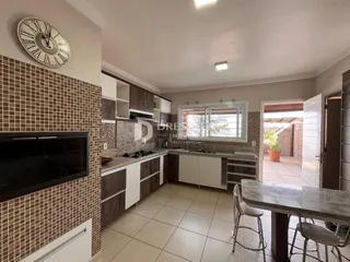 Uma cozinha com revestimento de cerâmica marrom e armários brancos.