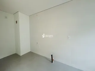 Uma vista interna de um ambiente com paredes brancas.