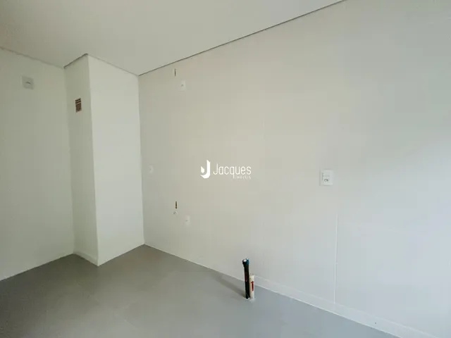 Uma vista interna de um ambiente com paredes brancas.