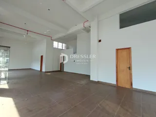 Ambiente interno de uma sala ampla com piso de cerâmica.