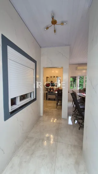 Corredor interno de uma residência com piso de mármore claro.