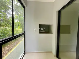 Vista interna de um ambiente com grande janela e vista para a natureza.
