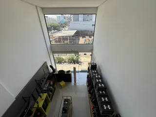 Vista de um corredor interno com grande janela de vidro em uma residência.