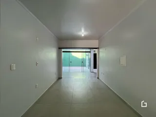 Corredor interno de uma residência com piso claro e paredes brancas.